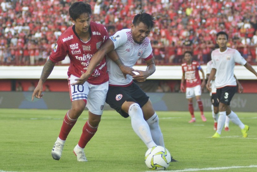 Pesepak bola Bali United Irfan Bachdim (kiri) berebut bola dengan pesepak bola Persija Jakarta Maman Abdurahman (kanan) saat pertandingan leg pertama perempat final Piala Indonesia di Stadion Kapten I Wayan Dipta, Gianyar, Bali, Jumat (26/4/2019). 