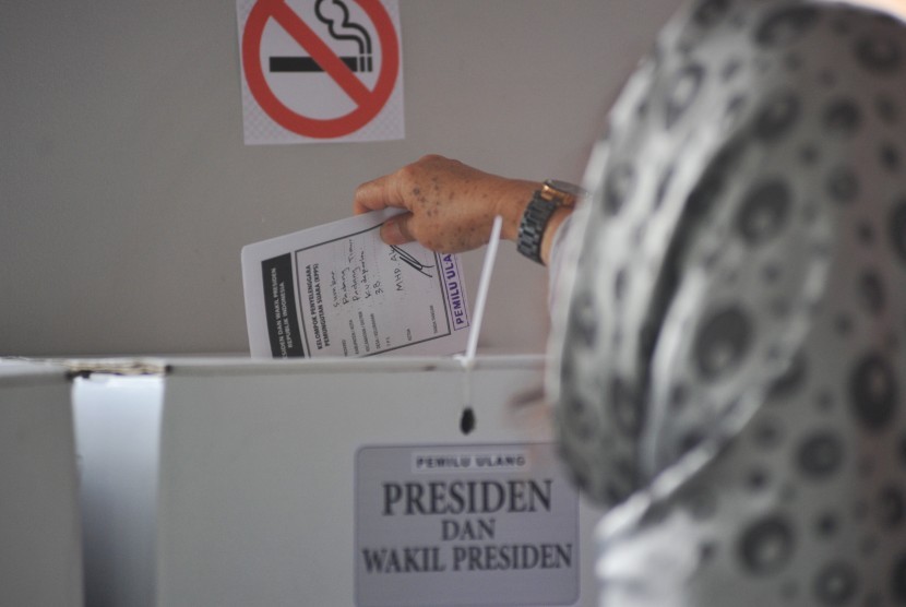 Warga memasukkan surat suara saat pemungutan suara ulang (PSU) Pemilu 2019 di TPS 38, Parak Karakah, Padang, Sumatera Barat, Sabtu (27/4/2019).
