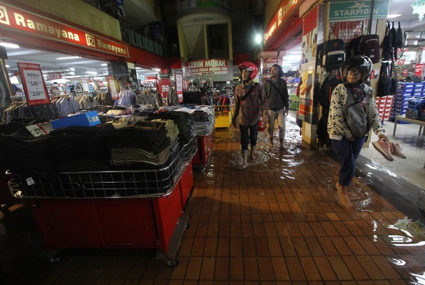 Pengunjung berjalan di samping pakaian yang dijual di Hi-Tech Mall yang terendam banjir di Surabaya, Jawa Timur, Senin (29/4/2019). 