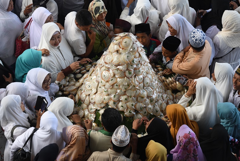 Warga bersiap-siap membagikan kue apem saat digelar 'Magengan Kubro' di Masjid Al Akbar Surabaya, Jawa Timur, Jumat (3/5/2019). 