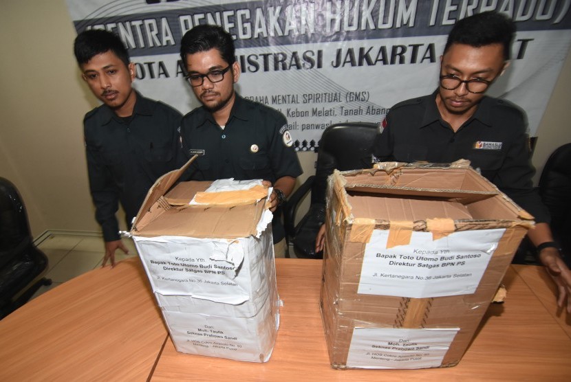 Petugas Bawaslu Jakarta Pusat menunjukkan kardus berisi ribuan form C1 Pemilu yang diamankan polisi dari sebuah mobil yang melaju di kawasan Menteng, Jakarta, di Gedung Bawaslu Jakarta Pusat, Senin (6/5/2019).