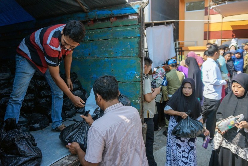 Warga antre mendapatkan bahan sembako saat pasar murah Ramadhan di Pekalongan, Jawa Tengah, Selasa (7/5/2019).