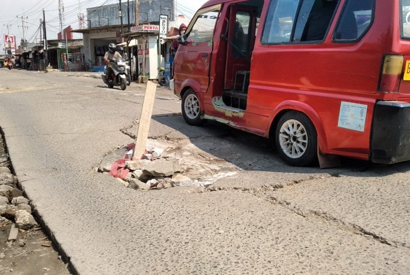 Angkot sedang melintasi Jalan Raya Babelan, Desa Babelan Kota, Babelan, Kabupaten Bekasi, Selasa (7/5). Jalan penghubung Kabupaten dan Kota Bekasi itu telah mengalami kerusakan parah sejak 2 tahun terakhir. 