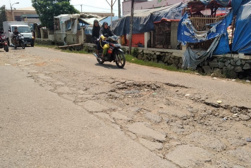 Sepeda motor sedang melintasi Jalan Raya Babelan, Desa Babelan Kota, Babelan, Kabupaten Bekasi, Selasa (7/5). Jalan penghubung Kabupaten dan Kota Bekasi itu telah mengalami kerusakan parah sejak 2 tahun terakhir. 