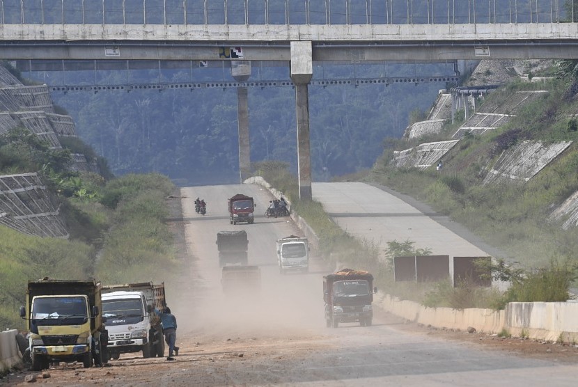 Sejumlah truk melintasi proyek pembangunan Jalan Tol Cileunyi-Sumedang-Dawuan (Cisumdawu) di Kabupaten Sumedang, Jawa Barat, Rabu (8/5/2019). 