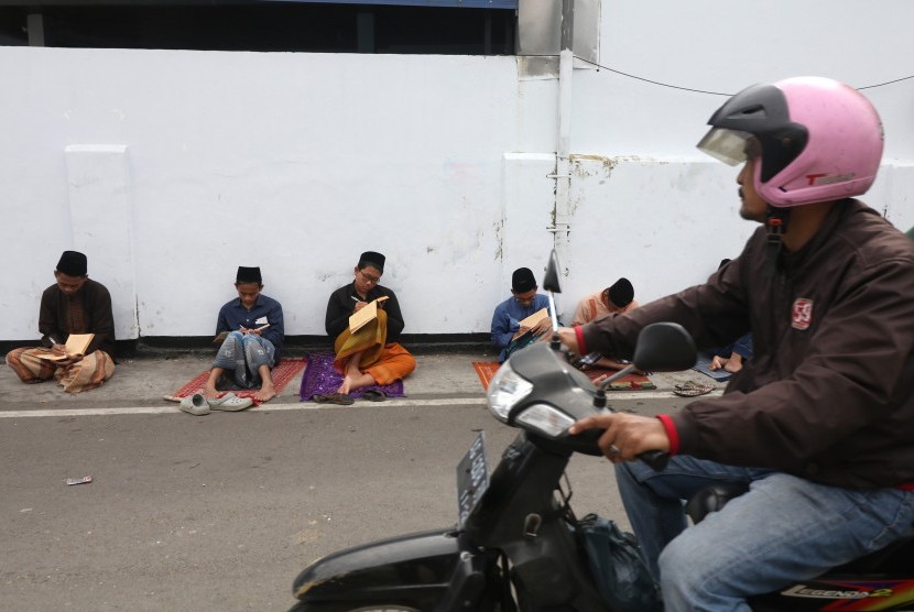 Pendiri Pesantren Lirboyo, Mbah Manab, meminta santri bermanfaat untuk umat. Sejumlah santri mengaji kitab kuning (kitab klasik berbahasa arab gundul) di pinggir jalan kompleks pondok pesantren Lirboyo, Kota Kediri, Jawa Timur. 