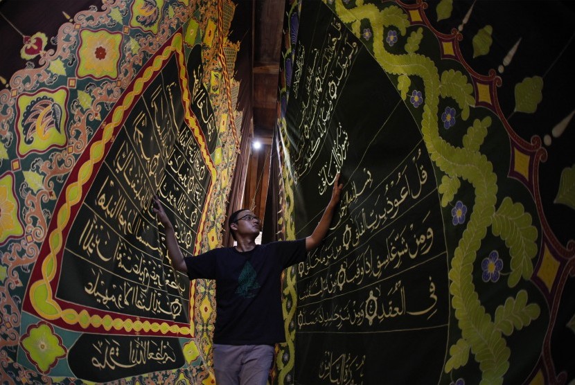 Perajin membuat batik motif ayat Al Quran di atas lembar kain di Mahkota Batik Laweyan, Solo, Jawa Tengah, Kamis (9/5/2019).