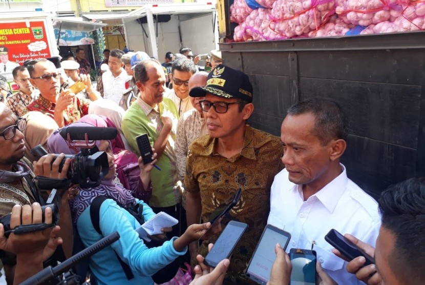 Gubernur Sumbar Irwan Prayitno bersama Kepala Badam Ketahanan Pangan Kementerian Pertanian Agung Hendriadi saat Operasi Pasar Bawang Putih di Pasar Raya Padang, Jumat (10/5).