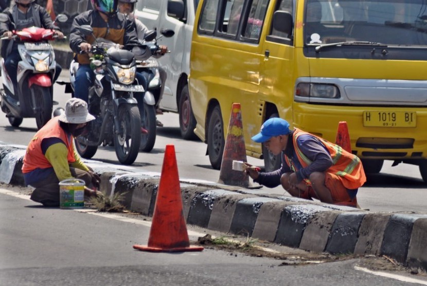 Pekerja PT Adhi Karya melakukan pengecatan median jalan di KM 19+700 di ruas Jalan Diponegoro Ungaran, Kabupaten Semarang, Jumat (10/5). Pekerjaan pemeliharaan jalan KBK ruas Banyumanik- Bawen ini juga diperuntukkan bagi penyiapan jalur utama non tol untuk mudik Lebaran tahun ini.