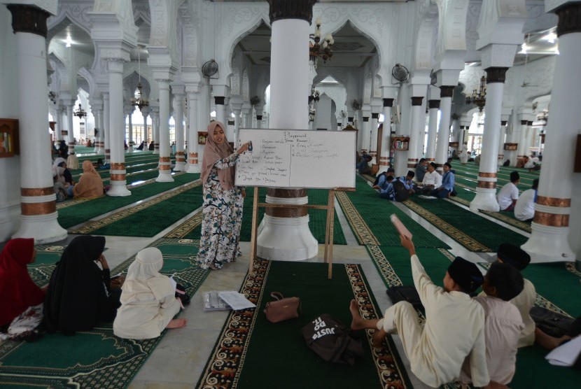 Ustazah memberikan pelajaran kepada santri di Masjid Raya Baiturrahman, Banda Aceh, Jumat (10/5/2019).