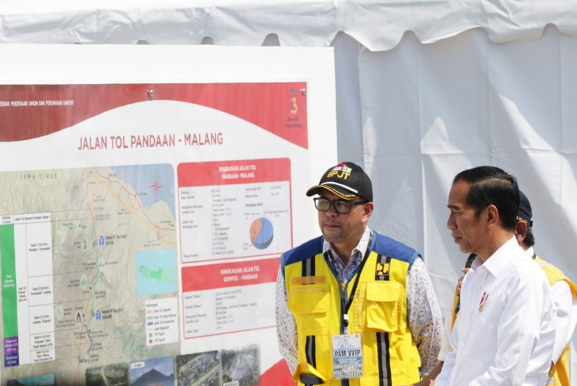 Presiden Joko Widodo (kanan) melihat peta tol Pandaan-Malang sebelum peresmian di gerbang tol Singosari, Malang, Jawa Timur, Senin (13/5/2019).