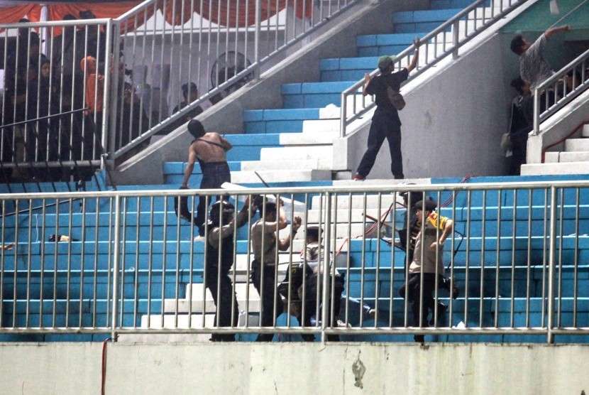Polisi menghalau pendukung yang ricuh saat pertandingan Liga 1 antara PSS Sleman melawan Arema FC di Stadion Maguwoharjo, Sleman, DI Yogyakarta, Rabu (15/5/2019). 