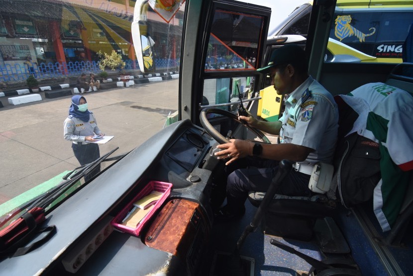 Petugas melakukan pengecekan kelayakan bus. 