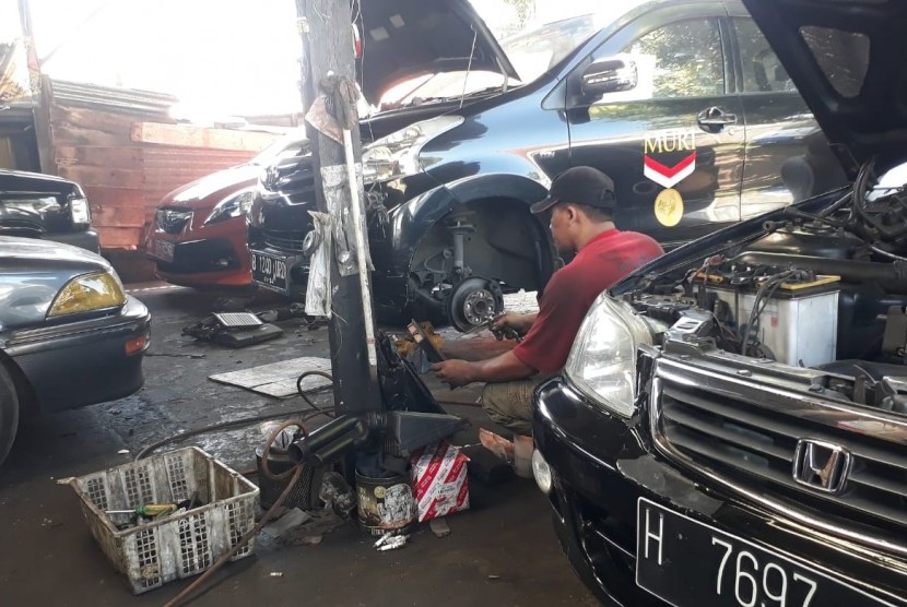 Seorang mekanik di Bengkel Mobil Anggi, Jalan Perintis Kemerdekaan, Semarang sedang melakukan aktivitas perawatan mesin. Asuransi Sinar Mas melakukan pembayaran klaim asuransi kendaraan kepada nasabah.