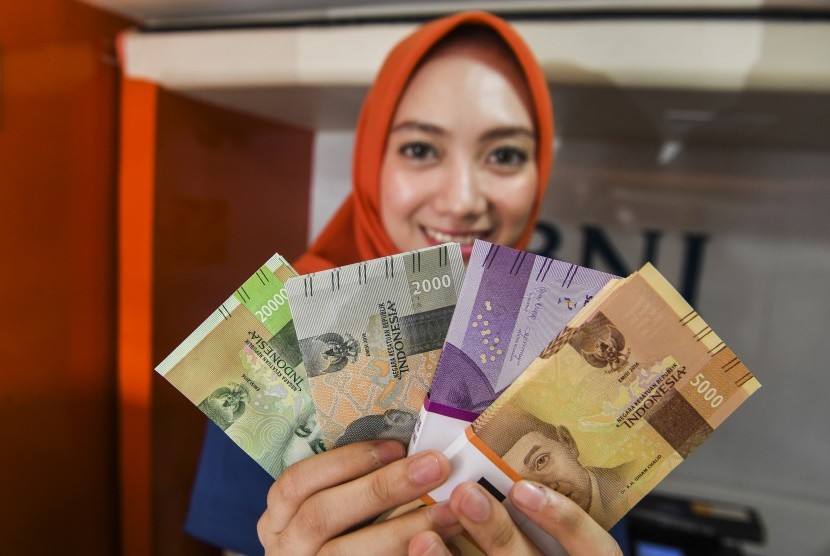 Petugas menunjukkan uang rupiah di layanan kas keliling di Monumen Juang, Bandung, Jawa Barat, Selasa (21/5/2019).