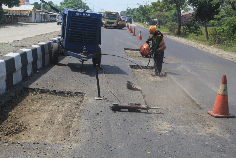 Pekerja menyelesaikan perbaikan jalur pantura Patrol, Indramayu, Jawa Barat yang saat ini banyak berlubang dan membahayakan pengemudi.
