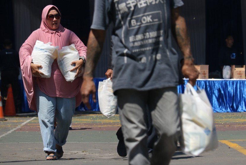 Warga membawa paket sembako gratis di Surabaya, Jawa Timur, Rabu (22/5/2019)