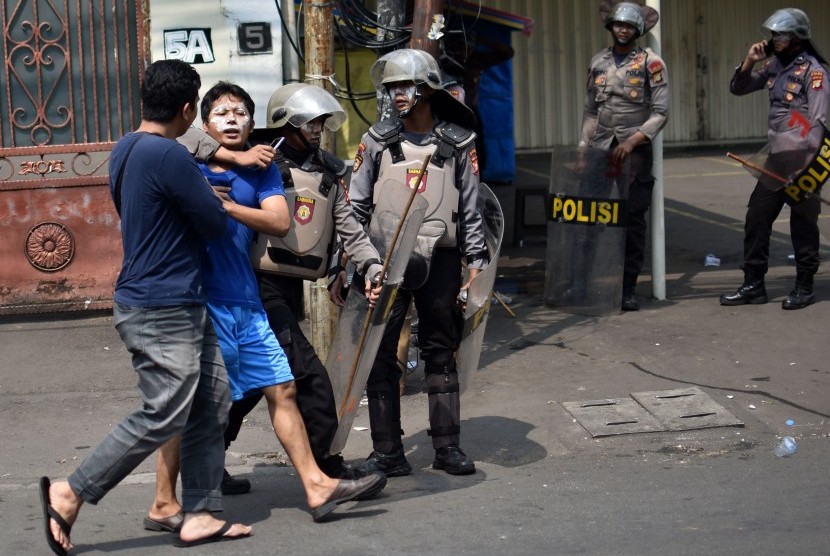 Sejumlah polisi mengamankan salah seorang warga yang diduga ikut aksi kerusuhan di Jalan KS. Tubun, Petamburan, Jakarta Pusat, Rabu (22/5/2019). 