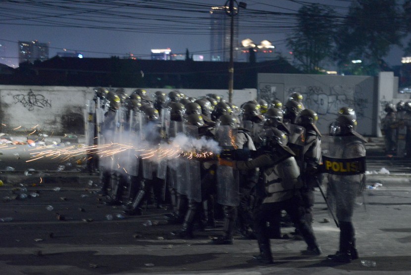 Personel kepolisian menembakkan gas air mata pada massa aksi 22 Mei di Jalan Brigjen Katamso, Slipi, Jakarta, Rabu (22/5/2019). 