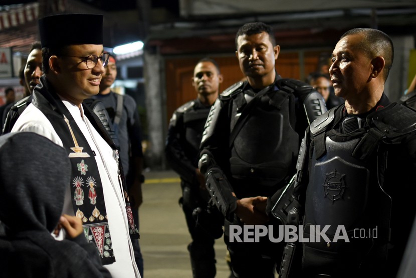 Gubernur DKI Jakarta Anies Baswedan (kiri) berbincang dengan z petugas polisi yang bertugas mengamankan kawasan sekitar Kantor Bawaslu RI di Jalan Wahid Hasyim, Jakarta Pusat, Jumat (24/5/2019) malam.