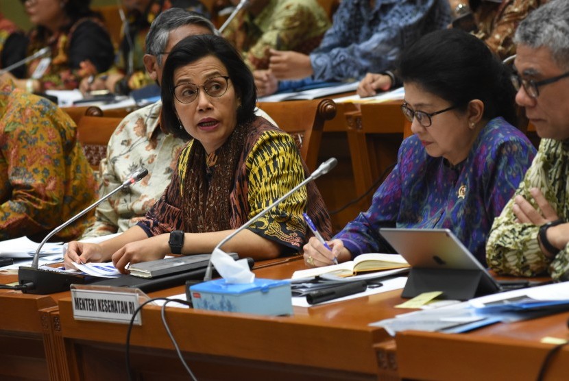 Menteri Keuangan Sri Mulyani Indrawati (kiri) dan Menteri Kesehatan Nila F. Moeloek (tengah) menyampaikan paparannya saat mengikuti rapat kerja dan rapat dengar pendapat dengan Komisi IX DPR di Kompleks Parlemen Senayan, Jakarta, Senin (27/5/2019).