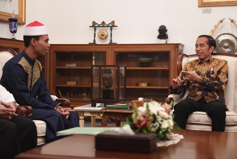 Presiden Joko Widodo (kanan) berbincang dengan pemenang Musabaqah Tilawatil Quran (MTQ) Internasional Ke-7 di Turki, Syamsuri Firdaus (kiri) dalam pertemuan di Istana Merdeka, Jakarta, Selasa (28/5/2019).