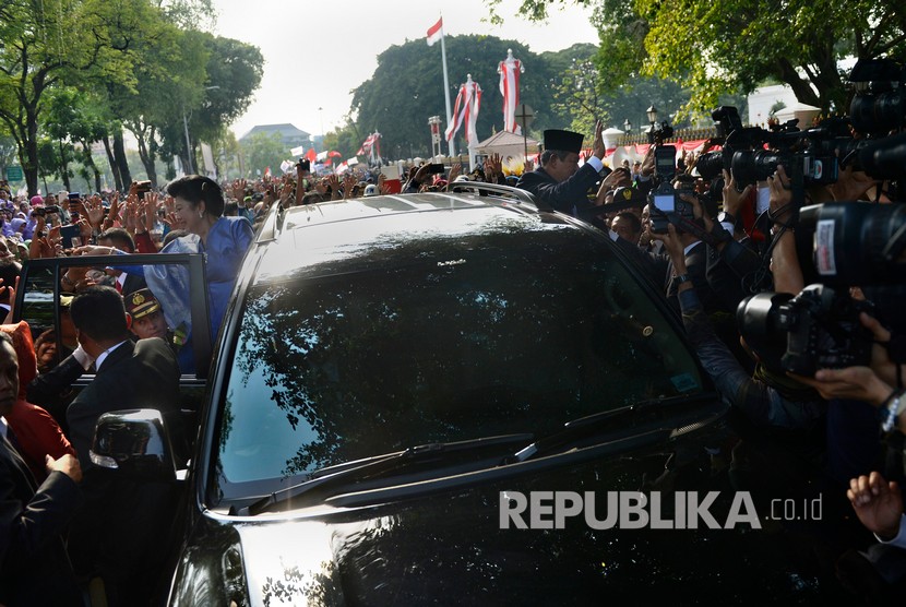 Presiden RI Ke-6 Susilo Bambang Yudhoyono (kanan) dan Ibu Ani Yudhoyono menyapa warga saat meninggalkan Istana Merdeka, Jakarta, Senin (20/10). 