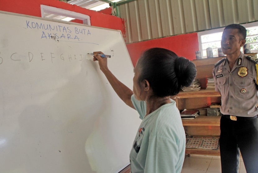 Seorang siswa buta aksara belajar menulis abjad, disaksikan Bhabinkamtibmas Brigpol Kresna Ola (kanan), di Rumah Merah Putih di desa Kenebibi, Kecamatan Kakuluk Mesak, Kabupaten Belu, NTT (ilustrasi) 