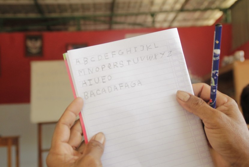 Seorang warga penyandang buta aksara menunjukkan hasil tulis tangannya saat belajar di Rumah Merah Putih di desa Kenebibi, Kecamatan Kakuluk Mesak, Kabupaten Belu, NTT, Sabtu (01/6/2019).