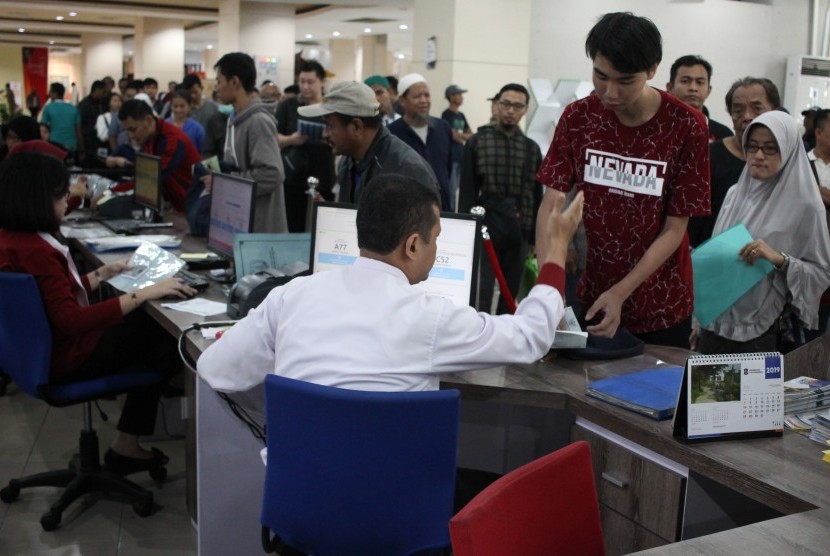 Petugas melayani warga yang mengurus dokumen kependudukan di Mall Pelayanan Publik Surabaya, Jawa Timur.  Berdasarkan survei Teropong Jatim, 95,4 persen masyarakat puas terhadap pelayanan surat-surat kependudukan di Surabaya.