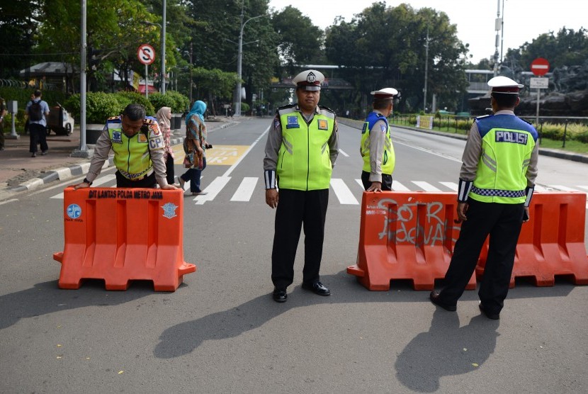 Polisi lalu lintas berjaga di ujung Jalan Medan Merdeka Barat yang ditutup di Jakarta, Jumat (14/6/2019). 