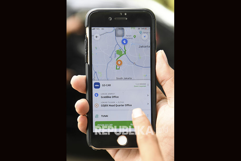 Warga menggunakan aplikasi untuk memesan taksi berbasis dalam jaringan (online) di Jakarta, Ahad (16/6/2019). 