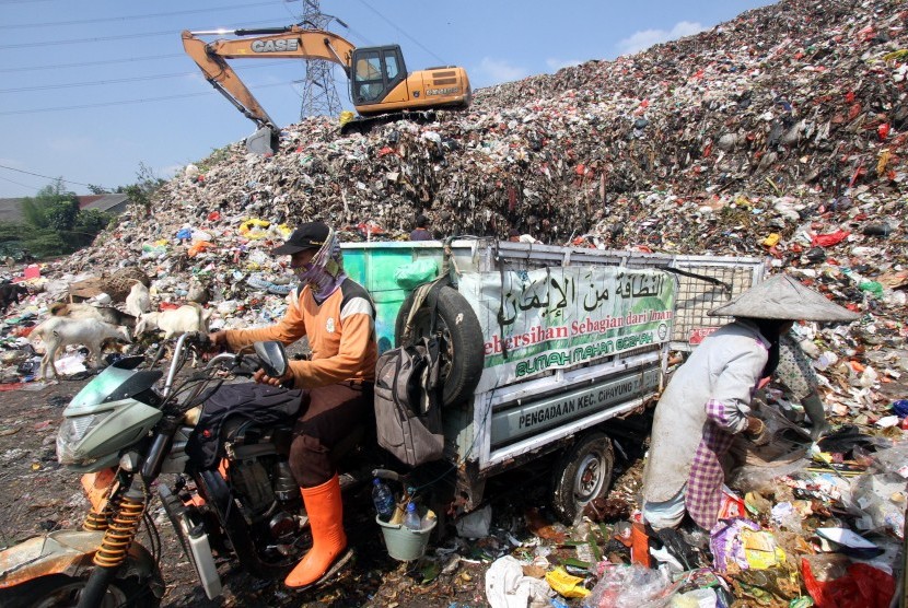 Pekerja membongkar muat sampah di Tempat Pembuangan Akhir (TPA) Sampah Cipayung, Depok, Jawa Barat.