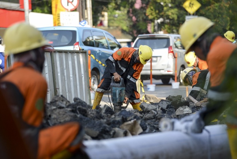 Pekerja membongkar trotoar lama di Jalan Cikini Raya depan Taman Ismail Marzuki (TIM), Jakarta, Rabu (19/6/2019).