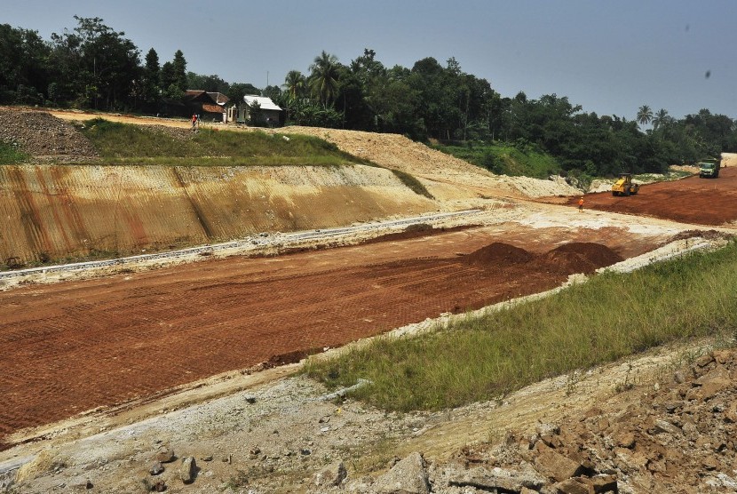 Sejumlah pekerja dengan menggunakan alat berat menyelesaikan proyek pembangunan jalan Tol Serang-Panimbang di Kampung Parongpong, Cukeusal, Serang, Banten, Jumat (21/6/2019).