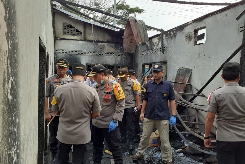 Petugas kepolisian melakukan identifikasi lokasi kebakaran pabrik korek api di Desa Sambirejo Kecamatan Binjai Kabupaten Langkat, Sumatera Utara, Jumat (21/6/2019). 