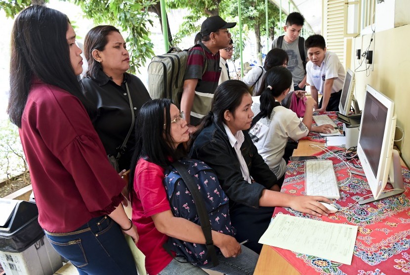 Sejumlah siswa dan orang tua murid mendaftar seleksi Penerimaan Peserta Didik Baru (PPDB) menggunakan komputer di SMAN 1 Jakarta, Jakarta, Senin (24/6/2019).