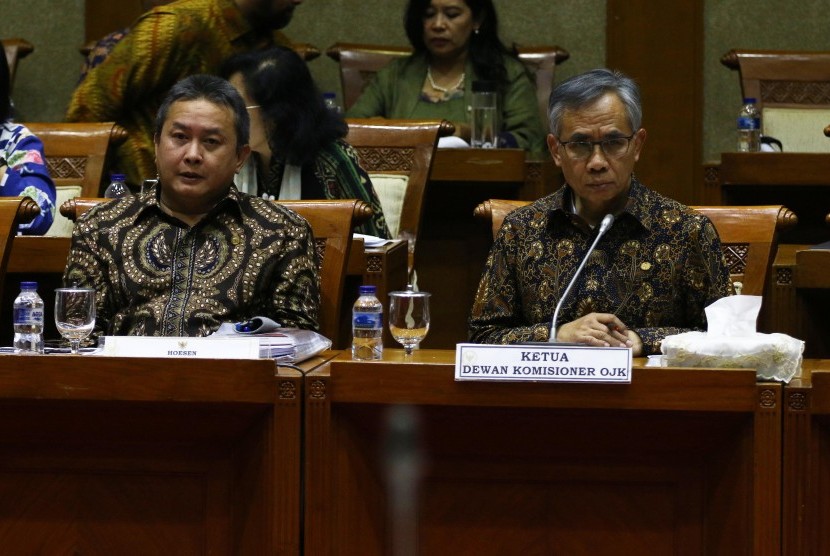 Ketua Dewan Komisioner Otoritas Jasa Keuangan (OJK) Wimboh Santoso (kanan) mengikuti rapat kerja bersama Komisi XI DPR di Kompleks Parlemen, Senayan, Jakarta, Kamis (27/6/2019).