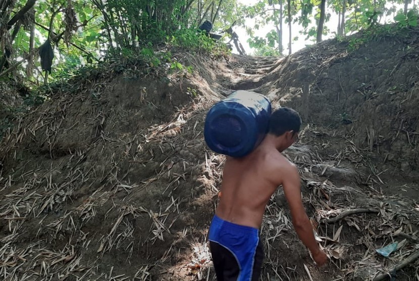 Warga Desa Ridogalih sedang mengambil air di Kali Cihoe yang mulai mengering pada Jumat (28/6). Desa Ridogalih merupakan satu dari tiga desa di Kecamatan Cibarusah, Kabupaten Bekasi, yang dilanda kekeringan sejak dua bulan terakhir. 