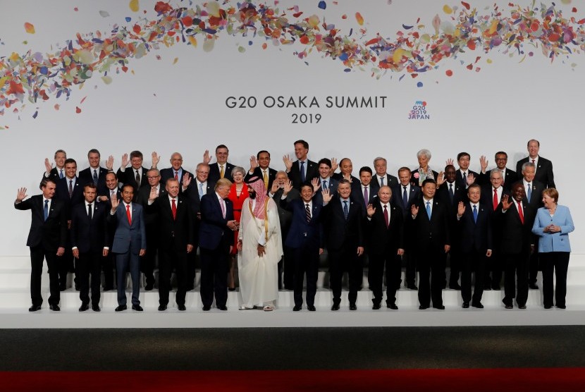 Presiden Joko Widodo (depan, tiga kiri) melambaikan tangan saat berfoto bersama para pemimpin negara-negara peserta KTT G20 di Osaka Jepang, Jumat (28/06/2019).