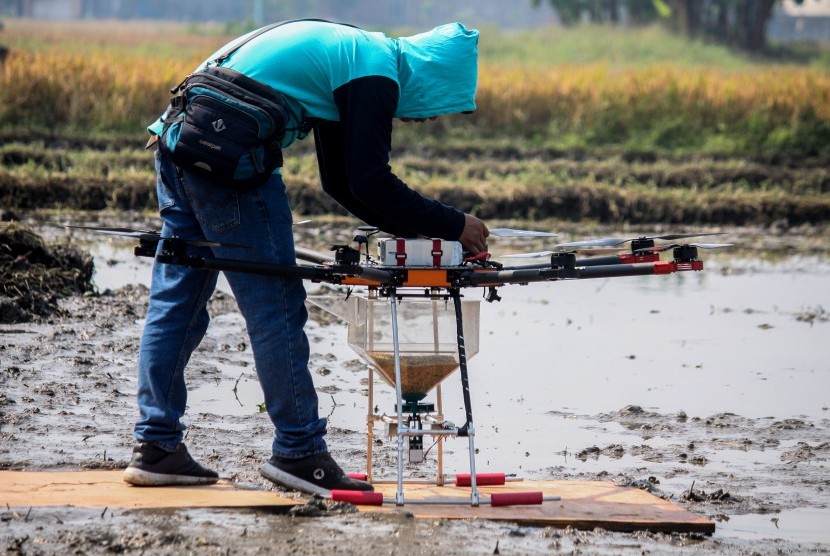 Teknisi melakukan uji coba penggunaan wahana tak berawak atau drone untuk menebar benih padi di Persawahan kawasan Krian, Sidoarjo, Jawa Timur, Sabtu (29/6/2019).