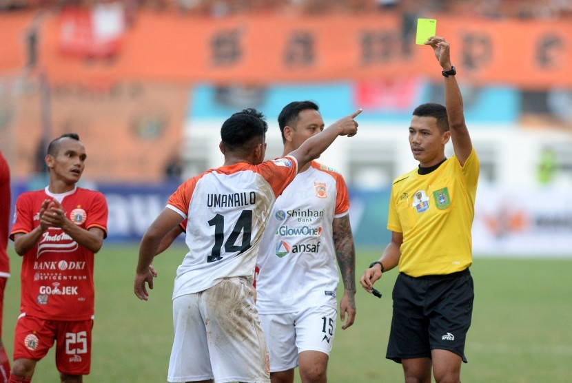 Wasit Wawan Rapiko (kanan) memberikan kartu kuning pada pesepak bola Borneo FC Abrizal Umanailo (ketiga kanan) saat melawan Persija Jakarta dalam pertandingan semifinal leg pertama Piala Indonesia di Stadion Wibawa Mukti, Cikarang, Kabupaten Bekasi, Jawa Barat, Sabtu (29/6/2019).