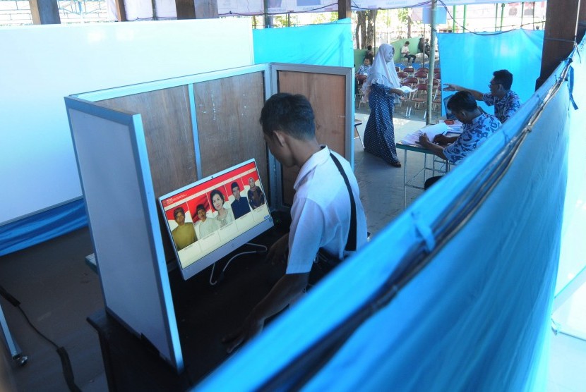 Pemilih mengamati foto calon kepala desa pada layar komputer saat melakukan pemilihan kepala desa (Pilkades) sistem 'e-voting' atau pemungutan suara berbasis elektronik di Kantor Desa Bendosari, Sawit, Boyolali, Jawa Tengah, Sabtu (29/6/2019).