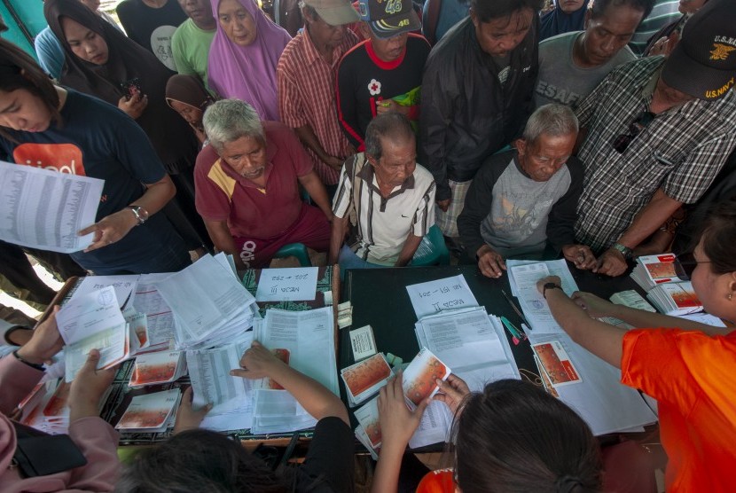 Sejumlah warga korban bencana antre untuk mendapatkan dana Jaminan Hidup (Jadup) yang mulai disalurkan di kompleks Hunian Sementara (Huntara) Desa Mpanau, Sigi, Sulawesi Tengah, Senin (1/7/2019). 