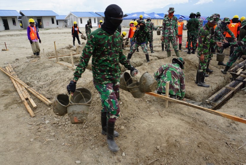 Personil TNI bersama sejumlah pekerja mengerjakan pembangunan hunian tetap (Huntap) bantuan Yayasan Budha Tzu Chi bagi korban bencana gempa, tsunami dan likuefaksi di Kelurahan Tondo, Palu, Sulawesi Tengah, Senin (1/7/2019).