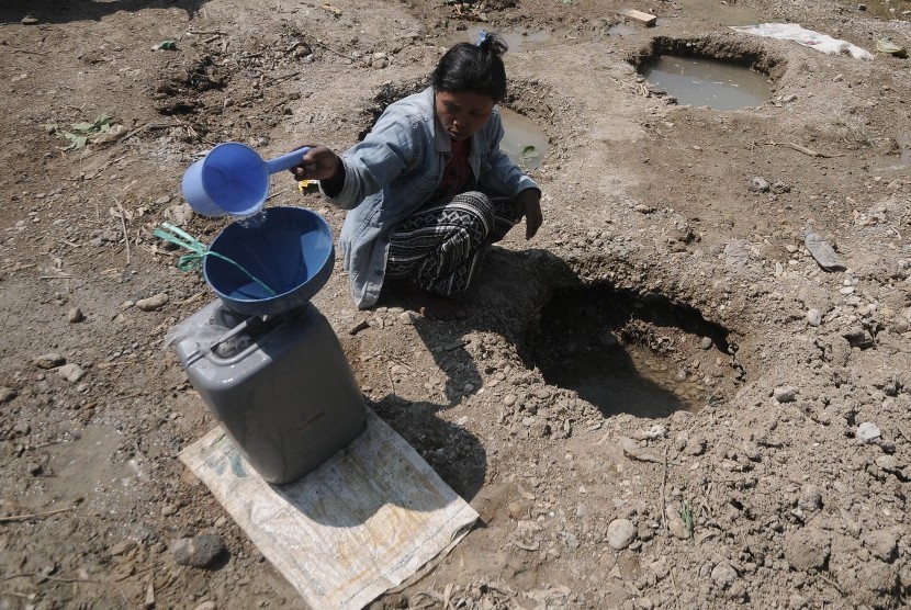 Warga mengambil air dari lubang yang digali di dasar sungai yang mengering di Dukuh Jati, Karangrayung, Grobogan, Jawa Tengah, Selasa (2/7/2019).