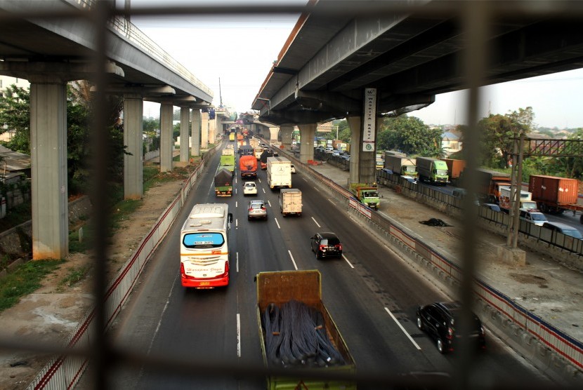 Sejumlah pengendara melintas di samping pengerjaan pembangunan Jalan Tol layang Jakarta-Cikampek II, di ruas Jalan Tol Jakarta-Cikampek, di Bekasi, Jawa Barat, Selasa (2/7/2019).