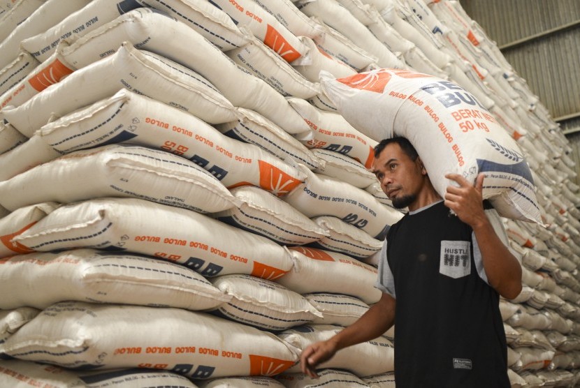 Pekerja memanggul karung beras Bulog di Gudang Bulog Kelapa Gading, Jakarta, Kamis (4/7/2019).