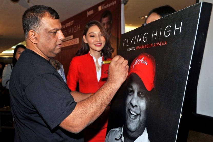 CEO AirAsia Group Tony Fernandes (kiri), menandatangani poster saat peluncuran bukunya yang berjudul Flying High: Kisahku Membangun AirAsia, di Jakarta, Kamis (4/7/2019).