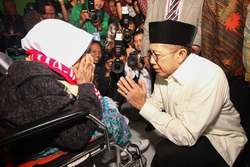 Menteri Agama Lukman Hakim Saifuddin (kanan) menyambut jamaah calon haji di asrama haji embarkasi Surabaya, Jawa Timur, Jumat (5/7/2019). 